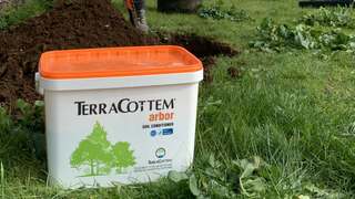 TerraCottem Arbor in front of pile of soil as someone is digging a hole for planting